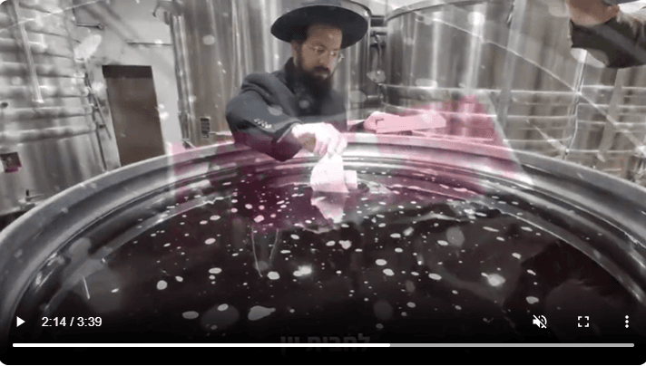 Rabbi Shmueli's son places the parchment in the wine